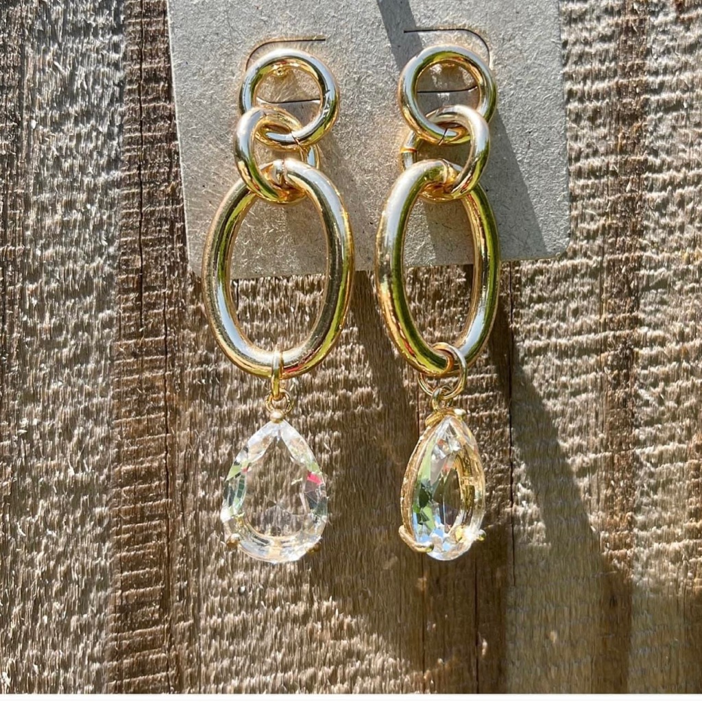 1 Pair Of Gold Metallic Hoops Earrings With Dangling Pear Shaped Crystals.